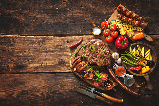 Cutting board with cooked lamb and vegetables