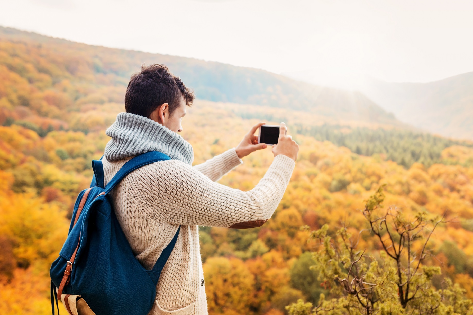 Man taking image of fall mountain scenery